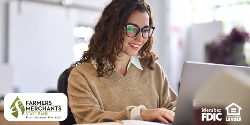 Woman smiling and looking at laptop screen