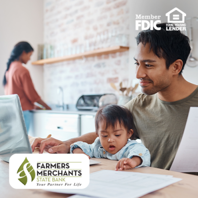 Father financially planning with a laptop at a table with his child on his lap